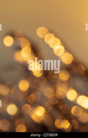 Unschärfes Bild von Lichtern, goldener Farbton. Mehrlagige goldene Bokeh-Punkte. Hochauflösender abstrakter Hintergrund mit Kopierbereich. Stockfoto