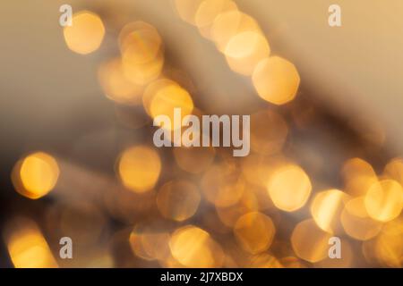 Unschärfes Bild von Lichtern, goldener Farbton. Mehrlagige goldene Bokeh-Punkte. Hochauflösender abstrakter Hintergrund mit Kopierbereich. Stockfoto