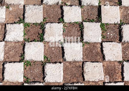 Bürgersteig in Quadraten . Pflastersteine und Boden . Symmetrische Form Figuren Oberfläche Stockfoto