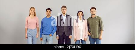 Porträt von smarten jungen Vertretern des modernen Business-Teams, die in der Reihe stehen. Stockfoto