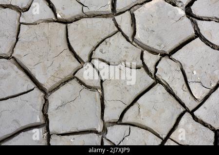 Abstrakter Hintergrund von feinem trockenen rissenen Schlamm bei Ebbe in Mündung des Flussbettes Stockfoto