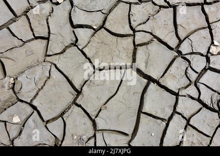 Abstrakter Hintergrund von feinem trockenen rissenen Schlamm bei Ebbe in Mündung des Flussbettes Stockfoto