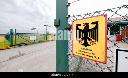 Bramstedtlund, Deutschland. 11.. Mai 2022. An einem Zaun am Eingang zur Aufklärungsstelle der Bundeswehr in Bramstedtlund hängt ein Schild mit der Aufschrift „Battalion Electronic Warfare 911“. Verteidigungsminister Lambrecht besuchte diese Einrichtung am 13. April 2022, in der nach Emissionen im elektromagnetischen Spektrum gesucht, erkannt und bewertet wird. Quelle: Markus Scholz/dpa/Alamy Live News Stockfoto