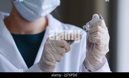 Nahaufnahme weibliche Hände in Latex-Handschuhe von unkenntlich Frau Arzt Krankenschwester in Schutzmaske wählt flüssige Medizin Antibiotika-Impfstoff Coronavirus Stockfoto