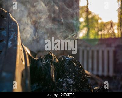 Charkiw Region, Charkow, Skovorodinovka, Skovorodinivka, Ukraine - 05.07.2022: Brennendes Schwelbrand rauchendes Stück Holzmetallfragmente zerstört Stockfoto