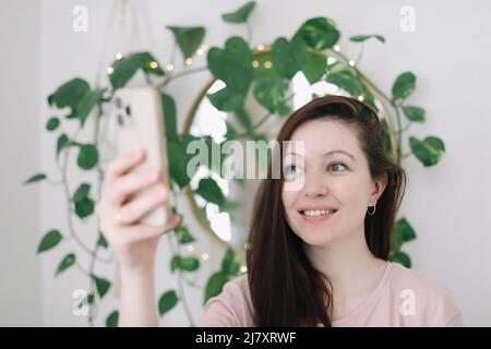 Porträt einer lächelnden, lässigen Frau, die das Smartphone hält Stockfoto
