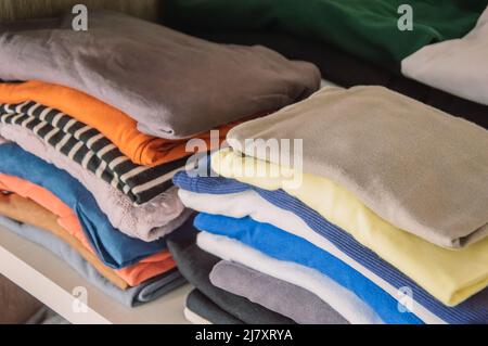 Bunte, helle Kleidung im Schrank Stockfoto