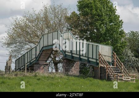 Alt und verlassenen jetzt stillgelegten Eisenbahn Fußgängerbrücke über die Bahnlinie lackiert blass und dunkelgrün Stockfoto