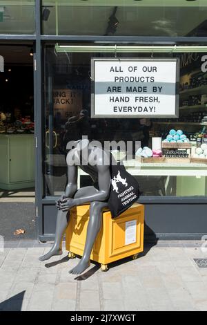 Kopflose Schaufensterpuppe auf gelber Schachtel vor dem Seifengeschäft und Parfümerie Cornhill Lincoln City 2022 Stockfoto