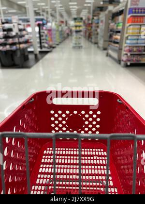 Roter Einkaufskorb in den verschwommenen Gängen eines Target Stores. Stockfoto