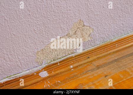Alte beschädigte Betonwand und Parkettboden. Verlassene Haus mit alten verwitterten Wand. Stockfoto
