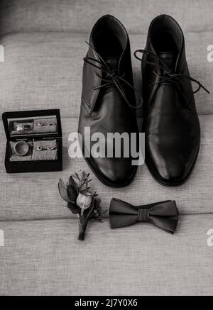 Hochzeitsdetails. Mann Accessoires. Gromm Schuhe, Ring, Blume und Krawatte. Stockfoto