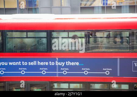 Passagiere, einige tragen eine Maske, andere nicht, werden in einem Doppeldeckerbus in der City of London gesehen. Stockfoto