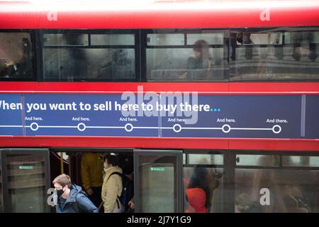 Passagiere, einige tragen eine Maske, andere nicht, werden in einem Doppeldeckerbus in der City of London gesehen. Stockfoto