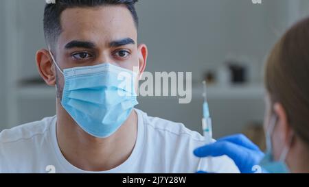 Nicht erkennbare Ärztin in Handschuhen hält Spritze mit Impfstoff Medizin immer bereit Machen Sie Impfinjektion von Covid-19 Coronavirus zu krank Stockfoto