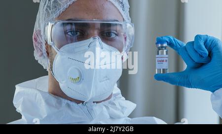Porträt eines männlichen Arztes der Arzt in der Schutzuniform gegen Coronavirus trägt eine Brille, eine Maske und Latexhandschuhe in den Handshows Stockfoto