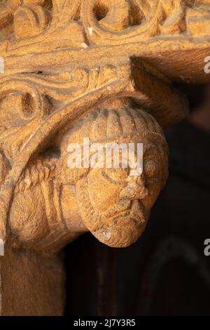 Die Schnitzerei eines bärtigen Mannes, der den Kopf trägt, starrt aus der Prior's Door in der Südwand des Kirchenschiffs der Ely Cathedral. Stockfoto