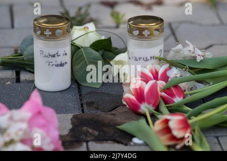Hanau, Deutschland. 11.. Mai 2022. Kerzen und Blumen gedenken der Opfer nach dem gewaltsamen Tod von zwei Kindern im Hof eines Hochhauses in Hanau. Während der genaue Hintergrund des Verbrechens noch unklar ist, geht die Polizei von einem familiären Hintergrund aus und sucht nach einem Verdächtigen. Quelle: Boris Roessler/dpa/Alamy Live News Stockfoto