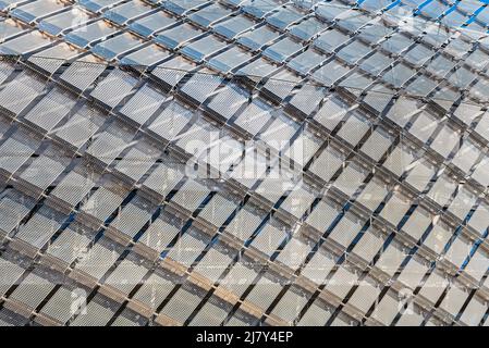 Muster aus Metalldiamanten an der modernen Gebäudefassade sieht aus wie ein Gefängnis. Das zeitgenössische Äußere zeigt ein Gefängnis - wie eine Struktur in moderner Architektur Stockfoto