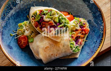 Eine Schüssel mit zwei Stücken vegetarischer Tortilla Stockfoto