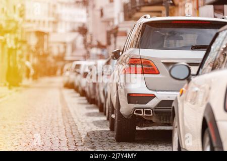 Viele Autos in Reihe auf der Straße in der Stadt in sonnigen Sommertag geparkt. Ökologisches Problem - Luftverschmutzung Stockfoto