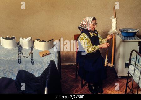 Eine Nonne, die Wolle spinnt. Seit 1954 blieb dieses Nonnenkloster vor den Behörden verborgen. Obwohl das Nonnenkloster „im Untergrund“ war, zog es immer wieder Frauen an, die am frühen Morgen eine Messe abhielten, bevor sie das heimliche Umfeld verließen, um zu regulären Jobs zu gehen. Stockfoto