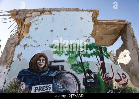 11. Mai 2022, Syrien, Binnish: Ein Wandgemälde aus Solidarität mit dem ermordeten palästinensischen Al Jazeera-Reporter Shireen Abu Aklei ist auf die Wand eines zerstörten Hauses in Idlib gemalt. Abu Aklei, 51, eine prominente Persönlichkeit im arabischen Nachrichtendienst des Al-Jazeera-Kanals, wurde heute während einer Konfrontation zwischen israelischen Soldaten und Palästinensern in der Stadt Jenin im Westjordanland getötet. Der katarische TV-Sender Al-Jazeera beschuldigt das israelische Militär des "Mordes", aber das israelische Militär sagt, Abu Aklei sei von palästinensischen Schützen geschossen worden, als sie mit seinen Truppen zusammenschlugen. Foto: Anas Alkharboutli/dpa Stockfoto