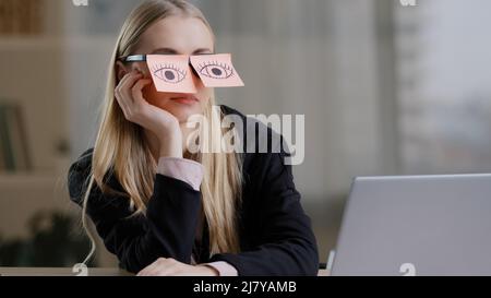 Müde, müde kaukasische Frau mit Haftnotizen auf den Augen Haftnotizen auf den Gläsern. Faul erschöpfte Frau sitzt am Schreibtisch fühlen sich gelangweilt Routine Arbeit Stockfoto