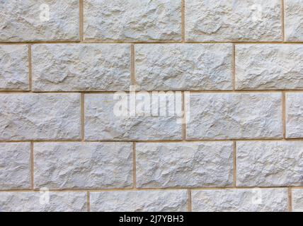 Vollformatbild der beigefarbenen Kalksteinwand. Für Hintergrund, Poster, Loft-Stil, Textur, viel Platz für Text. Stockfoto