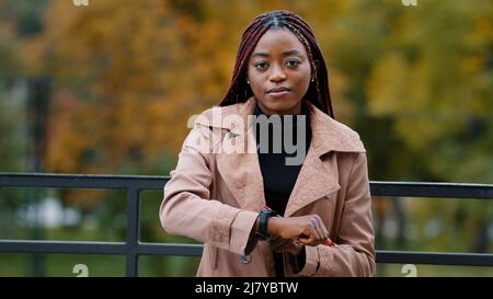 Die Zeit ist knapp, beeilen Sie sich, um zu spät zu sein Konzept. Junge Frau zeigt auf der Wache, Minuten zählen, hetzen. Portrait von schönen afroamerikanischen Mädchen Stockfoto