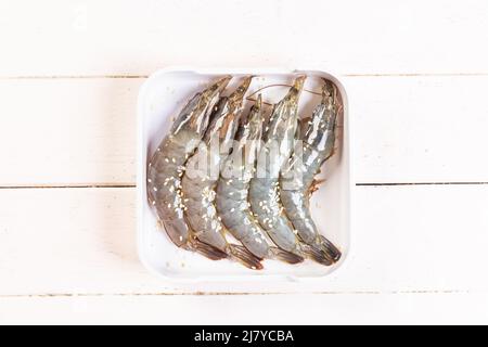 Frische rohe Garnelen Draufsicht auf weißem Teller, Prinkle mit weißem Sesam auf den Tisch. Stockfoto