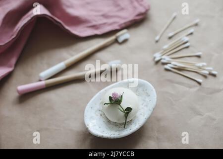 Handgemachte Naturseife, hölzerne Zahnbürsten, Wattestäbchen und Haarbürste auf Bastelpapier-Hintergrund Draufsicht mit Copyspace. Konzept der Kunststoff frei und Stockfoto