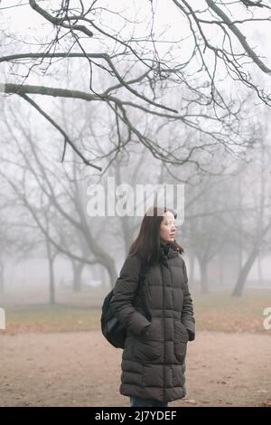 Junge Frau im nebligen Morgen im Herbstwald. Hochwertige Fotos Stockfoto