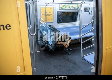 Ein Obdachloser schläft am Samstag, den 30. April 2022, in einem U-Bahn-Zug der E-Linie in New York. (© Richard B. Levine) Stockfoto