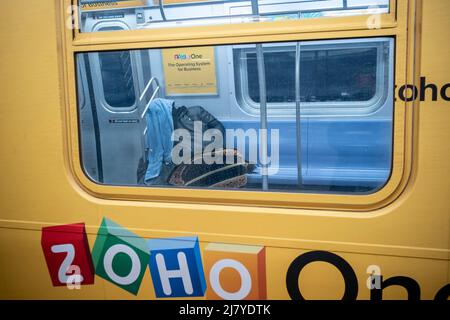 Ein Obdachloser schläft am Samstag, den 30. April 2022, in einem U-Bahn-Zug der E-Linie in New York. (© Richard B. Levine) Stockfoto