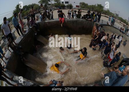 Lahore, Pakistan. 08.. Mai 2022. Die pakistanischen Menschen kühlen sich während des heißen Wetters in Lahore, Pakistan, am 8. Mai 2022 in einem Kanal ab. Im März und April erlebten Gebiete in Indien und im benachbarten Pakistan extreme Hitze, die über eine Milliarde Menschen Temperaturen weit über 40 Grad Celsius (104 Fahrenheit) aussetzte. Die wärmsten Monate des Jahres stehen noch bevor. (Foto von Rana Sajid Hussain/Pacific Press/Sipa USA) Quelle: SIPA USA/Alamy Live News Stockfoto