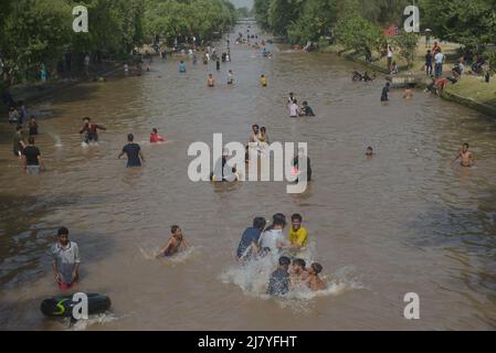 Lahore, Pakistan. 08.. Mai 2022. Die pakistanischen Menschen kühlen sich während des heißen Wetters in Lahore, Pakistan, am 8. Mai 2022 in einem Kanal ab. Im März und April erlebten Gebiete in Indien und im benachbarten Pakistan extreme Hitze, die über eine Milliarde Menschen Temperaturen weit über 40 Grad Celsius (104 Fahrenheit) aussetzte. Die wärmsten Monate des Jahres stehen noch bevor. (Foto von Rana Sajid Hussain/Pacific Press/Sipa USA) Quelle: SIPA USA/Alamy Live News Stockfoto