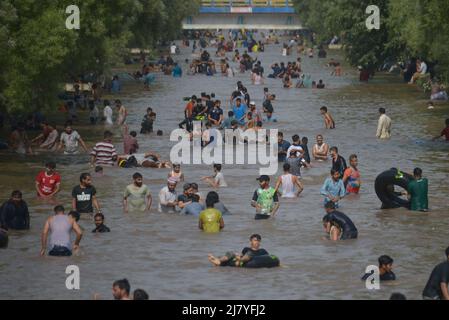 Lahore, Pakistan. 08.. Mai 2022. Die pakistanischen Menschen kühlen sich während des heißen Wetters in Lahore, Pakistan, am 8. Mai 2022 in einem Kanal ab. Im März und April erlebten Gebiete in Indien und im benachbarten Pakistan extreme Hitze, die über eine Milliarde Menschen Temperaturen weit über 40 Grad Celsius (104 Fahrenheit) aussetzte. Die wärmsten Monate des Jahres stehen noch bevor. (Foto von Rana Sajid Hussain/Pacific Press/Sipa USA) Quelle: SIPA USA/Alamy Live News Stockfoto