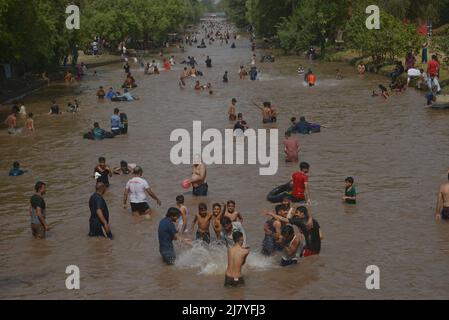 Lahore, Pakistan. 08.. Mai 2022. Die pakistanischen Menschen kühlen sich während des heißen Wetters in Lahore, Pakistan, am 8. Mai 2022 in einem Kanal ab. Im März und April erlebten Gebiete in Indien und im benachbarten Pakistan extreme Hitze, die über eine Milliarde Menschen Temperaturen weit über 40 Grad Celsius (104 Fahrenheit) aussetzte. Die wärmsten Monate des Jahres stehen noch bevor. (Foto von Rana Sajid Hussain/Pacific Press/Sipa USA) Quelle: SIPA USA/Alamy Live News Stockfoto