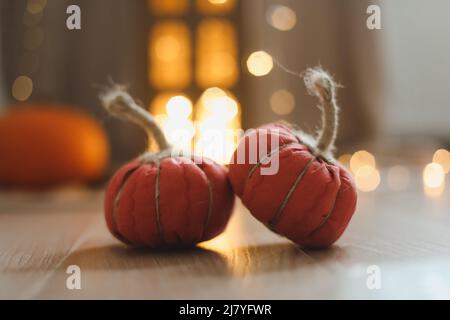 Herbstdekor mit gemütlichen Stoffkürbissen. Thanksgiving- und Halloween-Konzept. Stockfoto