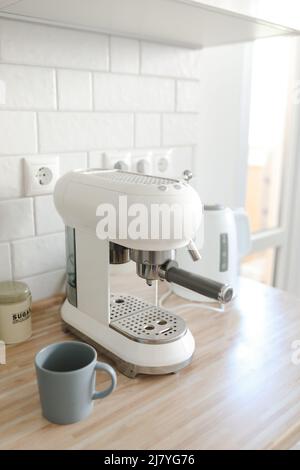 Weiße, stilvolle Kaffeemaschine in gemütlicher Küche Stockfoto