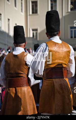 Rückansicht von zwei Männern in Lederkleidung und hohem Hut bei der 366-Grad-Volks-/Religionsprozession von Sant'Efisio in Cagliari Stockfoto