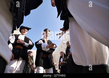 Niedrige Ansicht von Jungs, die alte Kleidung tragen, spielen in 'Morra', einem alten traditionellen Handspiel in Cagliari vor der Sant'Efisio Prozession Stockfoto