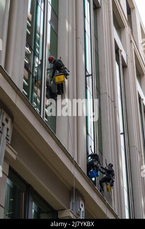 Abseilen von Fensterputzern, die in einem Bürogebäude arbeiten. London, England, Großbritannien Stockfoto