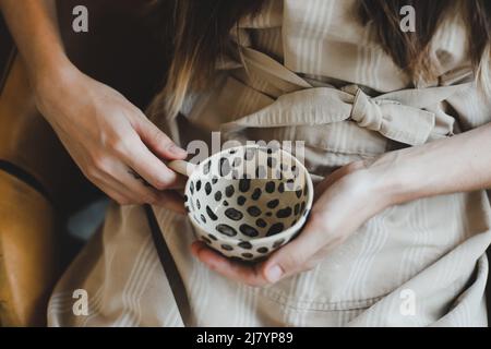 Foto eines Keramikbechers in der Nahaufnahme der weiblichen Hände Stockfoto