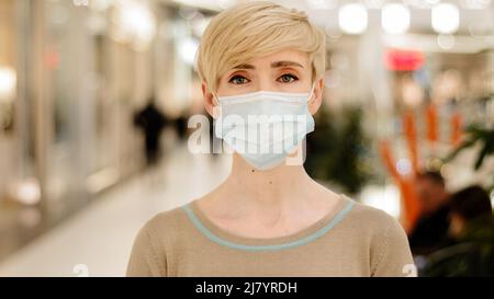 Portrait Geschäftsfrau mittleren Alters mit kurzem Haarschnitt 40s Dame Erwachsene Frau trägt medizinische Schutzmaske Blick auf Kamera Shopper Verbraucher in Stockfoto