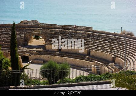 TARRAGONA, SPANIEN - 3. OKTOBER 2019 Römisches Amphitheater mit dem Meer im Hintergrund Stockfoto