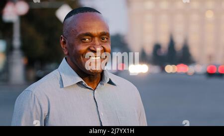 afroamerikanischer erwachsener Mann trägt formelles Hemd, glücklich lächelndes männliches Gesicht mit Falten, erfolgreiche elegante reife Geschäftsmann Chef Führer erlebt Stockfoto