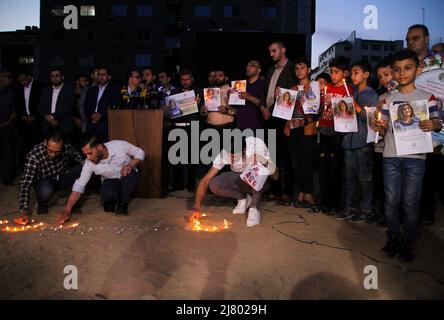 Gaza-Stadt, Gazastreifen, Palästina. 11.. Mai 2022. Gaza, Palästina. 11 Mai 2022. Die Union islamischer Radios und Fernsehgeräte hält eine Mahnwache ab, um den palästinensischen Journalisten Shireen Abu Aqleh zu gedenken und zu würdigen, der am Mittwoch von israelischen Truppen bei einem Überfall im Flüchtlingslager Dschenin im Westjordanland getötet wurde. Die Teilnehmer hielten Fotos von Shireen und zündeten Kerzen an, um dem Journalisten Respekt zu erweisen (Foto: © Ahmad Hasaballah/IMAGESLIVE via ZUMA Press Wire) Stockfoto