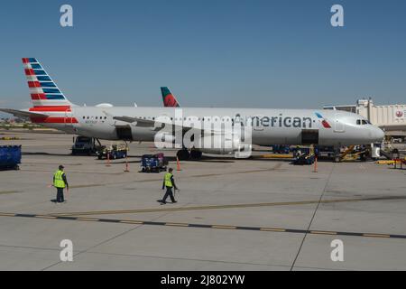 Mitarbeiter der Bodenbesatzung warten ein Passagierflugzeug des Typs Airbus A321 von American Airlines am internationalen Flughafen Phoenix Sky Harbor in Phoenix, Arizona. Stockfoto